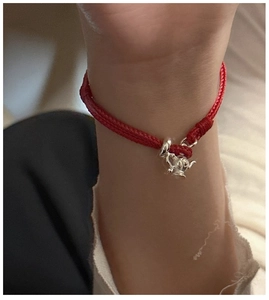 Close-up of S925 sterling silver teapot charm on a red braided rope bracelet