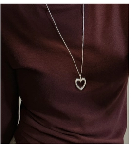 Detail showing high-polished hollow heart pendant on a fine silver chain necklace