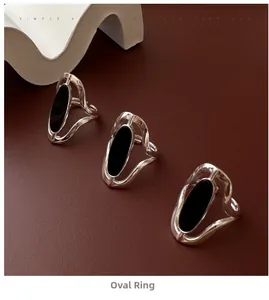 Detailed view of three silver S925 rings with black oval agate on textured wave bands