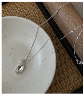 Detail of S925 sterling silver necklace featuring oval pendant and white round pearl