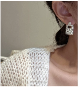 Detailed view of square hammered texture S925 sterling silver earrings on model