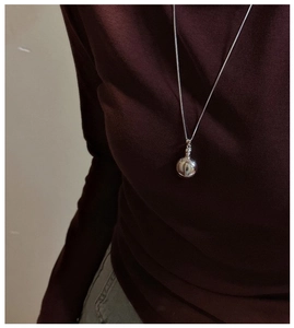 Detailed view of an S925 sterling silver minimalist round pendant necklace worn on a model