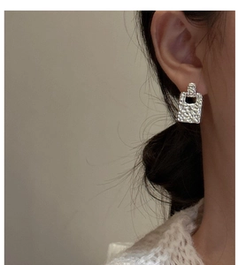 Close-up of S925 sterling silver earrings featuring hammered texture and hollow design