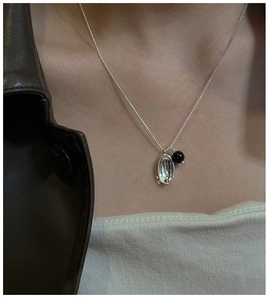 Detail view of S925 sterling silver necklace with pearl and agate pendant on model
