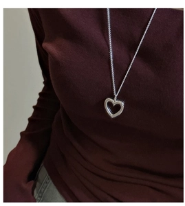 Close-up of S925 silver hollow heart pendant necklace on dark red knit sweater