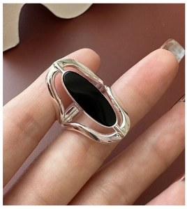 Macro shot of S925 sterling silver ring with oval black agate and hollow design