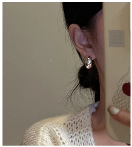 Close-up of minimalist S925 sterling silver C-shaped stud earrings worn on the ear
