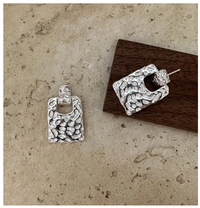 Detail of S925 sterling silver earrings with textured hammered finish and rectangle design