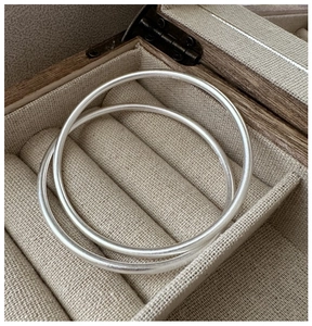 Macro shot of S999 sterling silver bracelets with matte frosted texture in a jewelry box