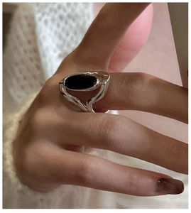 Close-up of S925 silver ring with oval black onyx stone worn on finger for casual style