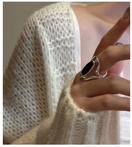 Detailed close-up of a silver S925 ring featuring an oval black agate stone on a hand