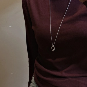 S925 sterling silver long teardrop necklace with abstract curved pendant on a model