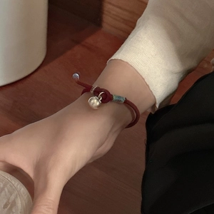 Traditional red braided bracelet with silver bell pendant in Neo-Chinese style