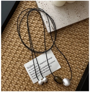 Detail of S925 silver brushed beads and brown stone on long black cord necklace