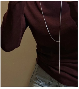 Detail of S925 sterling silver long lariat necklace with minimalist drop bar on a sweater