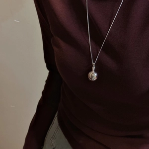 Minimalist S925 sterling silver long necklace with a polished sphere pendant on red knitwear