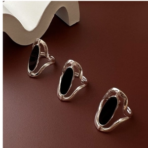 Detail of adjustable S925 silver rings with wavy edges and black agate inlay pieces