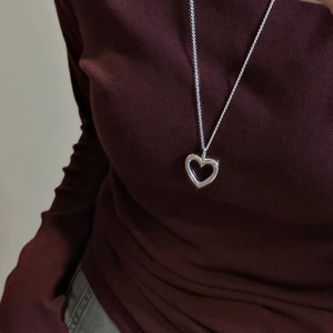 Minimalist S925 sterling silver hollow heart pendant necklace worn by a fashion model