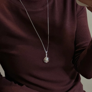 Minimalist S925 sterling silver round pendant necklace on a burgundy sweater