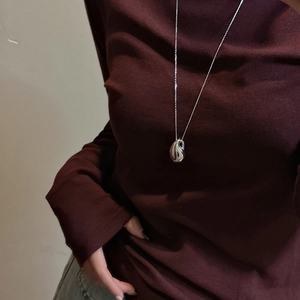 Collier minimaliste en argent S925 forme goutte d'eau sur un pull à col roulé bordeaux