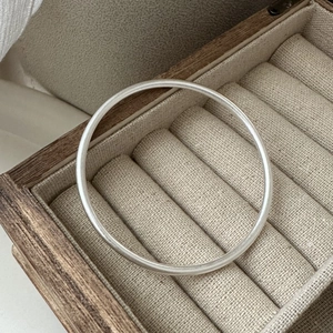 Minimalist S925 sterling silver frosted bangle with matte finish on a jewelry box