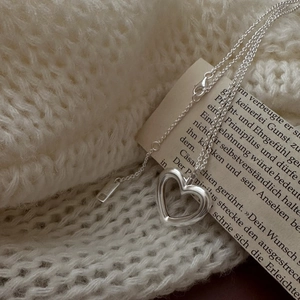 S925 sterling silver hollow heart necklace on cozy knit sweater with a vintage matte finish