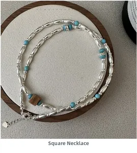 Detailed macro view of S925 silver beaded necklace with blue turquoise beads on a display stand