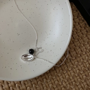 Minimalist S925 sterling silver necklace with pearl agate pendant on a ceramic plate