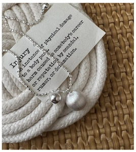 Detail of S925 silver necklace with matte and polished beads on artistic background