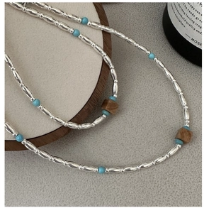 Detail of S925 silver cylinder beads and turquoise stone beads on a minimalist necklace