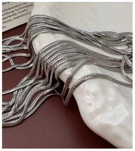 Detail shot of shimmering S925 sterling silver flat snake chains with metallic scale texture