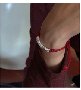 Detail of S925 sterling silver spiral tube on hand-woven red rope bracelet