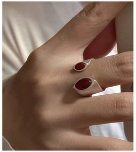 Macro shot of S925 sterling silver ring with oval red agate stones on female hand