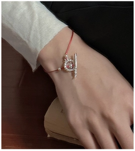 Detail of red rope bracelet with silver OT toggle clasp and hammered texture finish