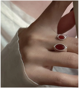Detail of S925 sterling silver ring featuring two oval red agates on a model's finger