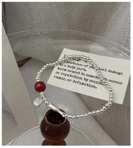 Detail of S925 silver beaded bracelet featuring a red cinnabar bead and Fu character charm