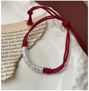 Close-up of S925 sterling silver hammered beads on handmade braided red cord bracelet