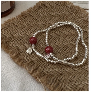 Close-up of S925 sterling silver beaded bracelet with Fu character charm and red beads
