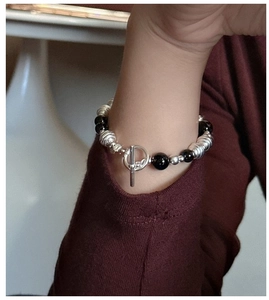 Close-up of S925 silver beaded bracelet with black agate beads and toggle clasp on wrist