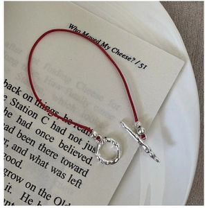 Detail of red string bracelet with silver OT toggle clasp and hammered texture finish