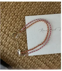Close-up of red woven rope bracelets with metal beads and adjustable lobster clasp closure