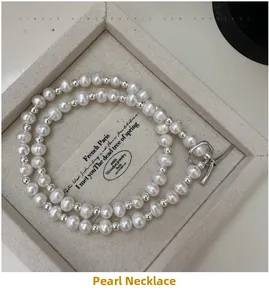 Macro detail of S925 silver pearl necklace with vintage OT toggle clasp on beige fabric