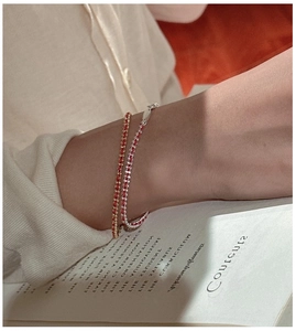 Close-up of handmade minimalist red string bracelets woven with gold and silver chains