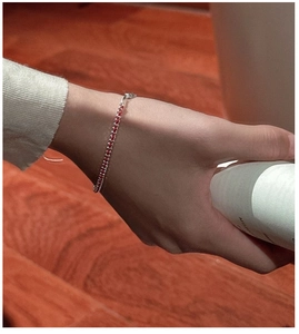 Macro view of minimalist handmade red braided rope bracelet with fine silver beads detail