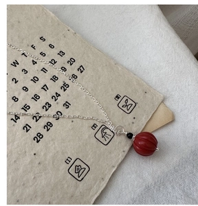 Gros plan détaillé du collier en argent S925 avec pendentif en cinabre rouge de style rétro