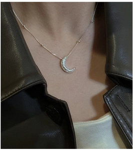 Close-up of S925 sterling silver crescent moon necklace with beaded chain on a model