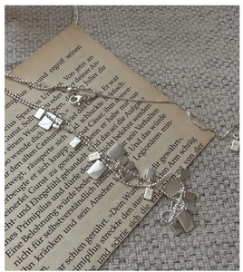 Dettaglio macro della collana d'argento regolabile su pagina di libro vintage