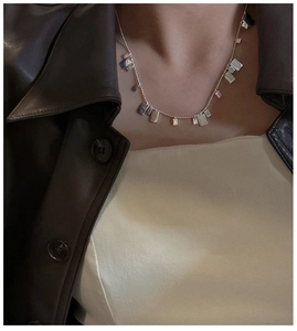 Dettaglio della collana in argento 925 con pendenti quadrati indossata con stile