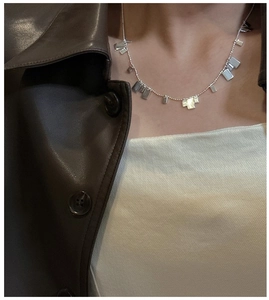 Dettaglio della collana in argento sterling 925 con pendenti quadrati indossata sul collo