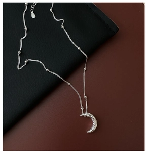 Detail of S925 sterling silver moon necklace featuring a hammered texture and beaded chain